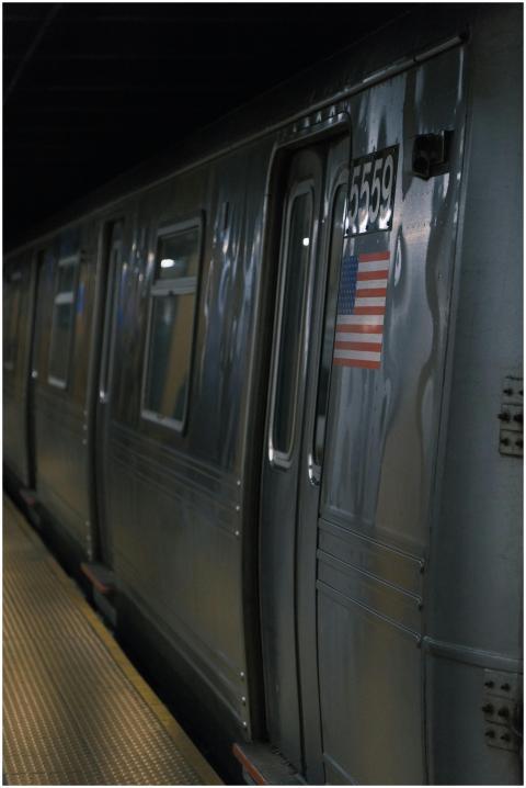A sleek subway train at a station with American fl