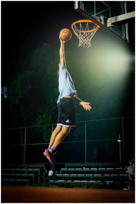 Man performing an impressive basketball dunk under