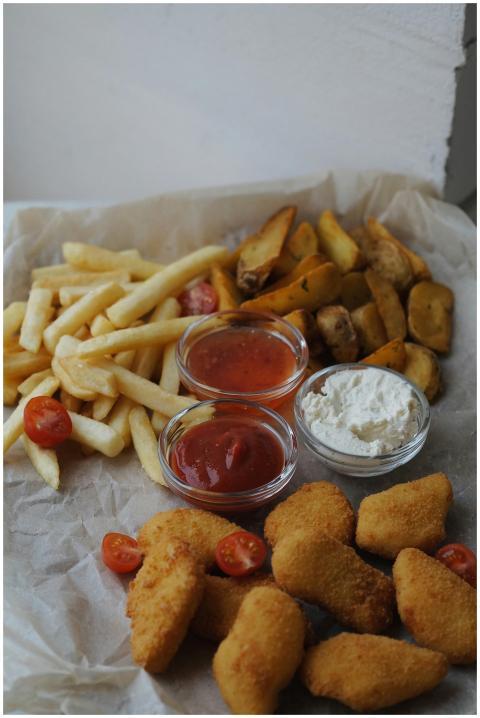 Assorted fried food with sauces on a rustic paper