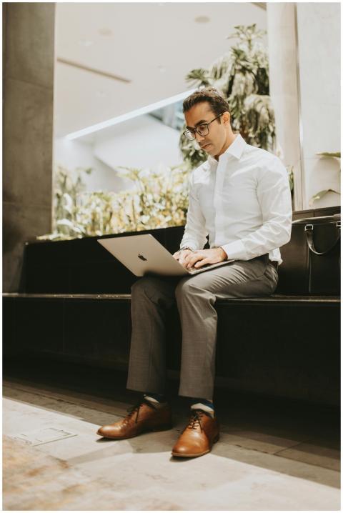 Businessman sitting with a laptop in a modern offi