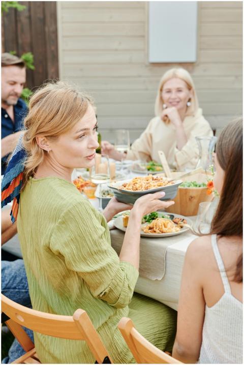 Family enjoying a meal together outdoors in a rela