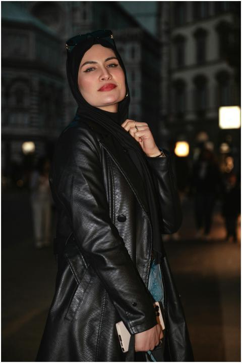 Stylish woman in black leather jacket posing in a