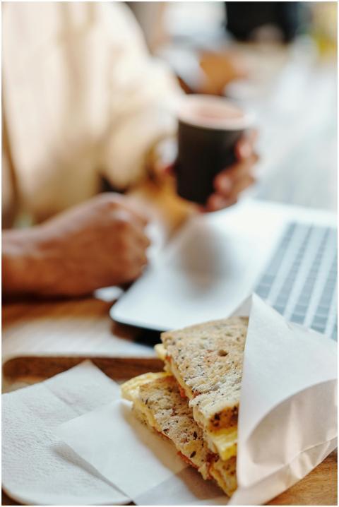 Close-up of a sandwich and coffee setup on a desk