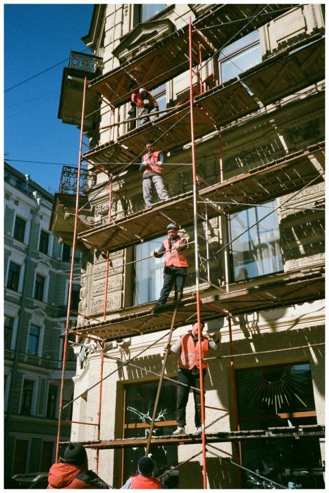 Construction workers on scaffolding renovating a b