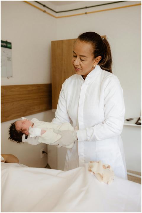 A caring obstetrician holding a newborn baby in a