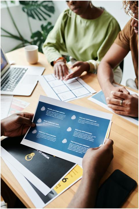 Team members collaborate over documents in an offi