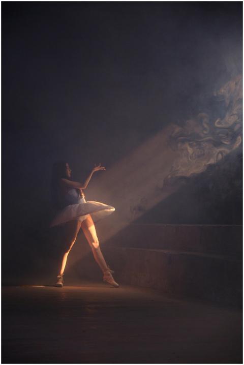 A graceful ballerina performing a dance in dramati