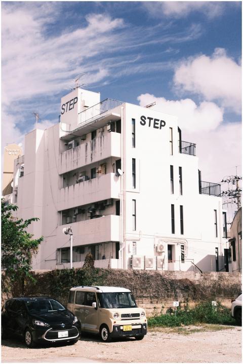 A modern white building with cars parked outside u