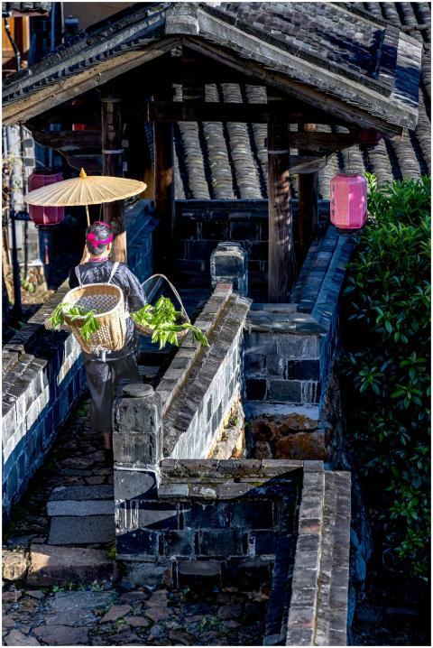 Traditional farmer carrying produce on a stone pat