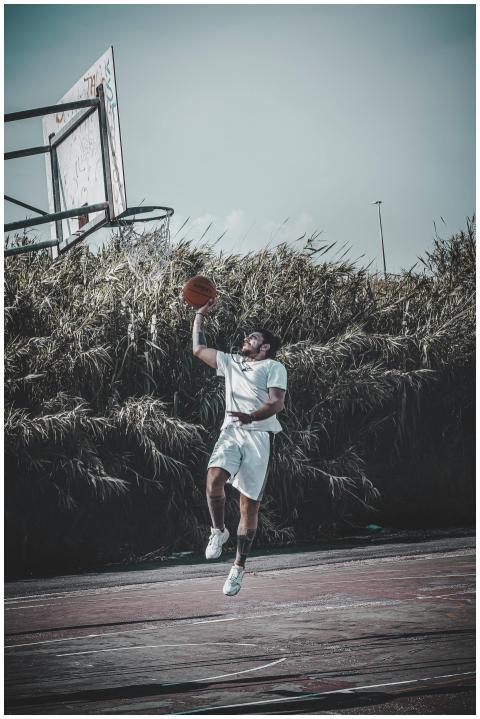 A basketball player makes a powerful dunk on an ou