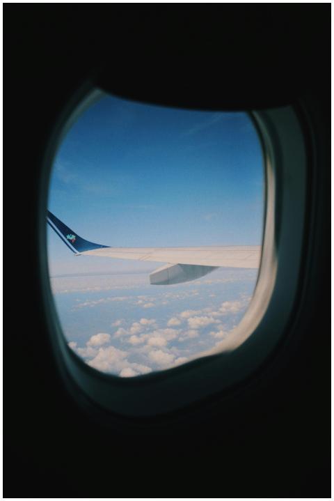 A serene view of sky and clouds through an airplan