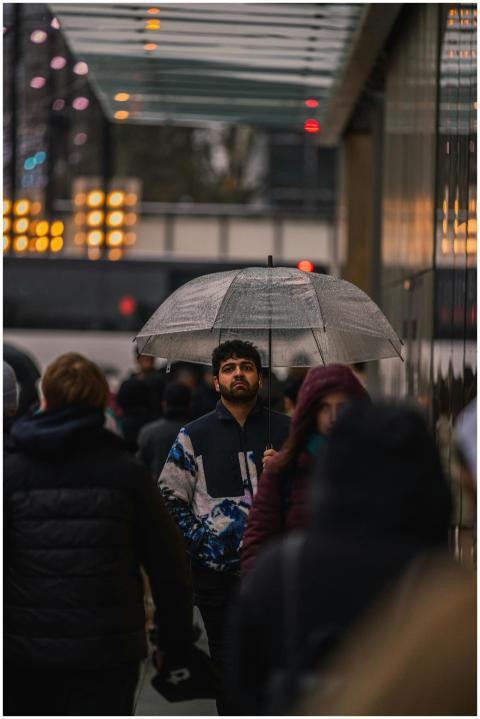 A man walks through rainy Vancouver protected by a