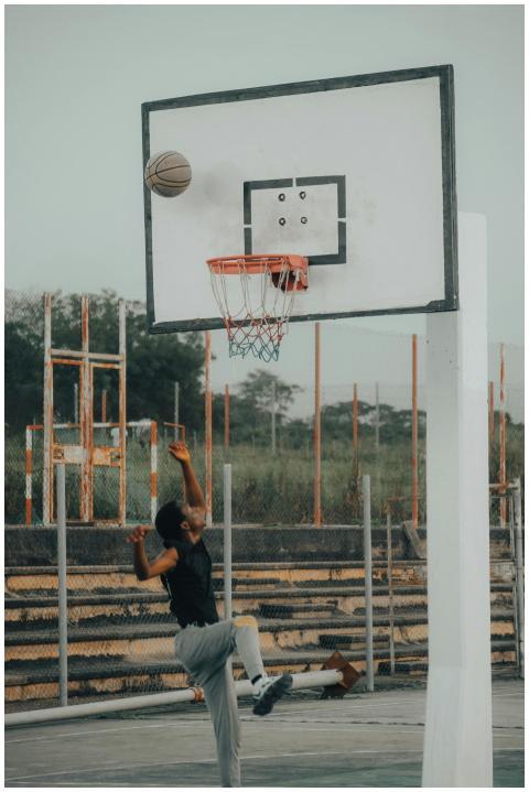 A young man shooting a basketball on an outdoor co