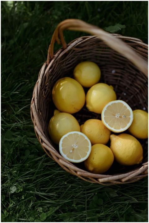 A wicker basket filled with fresh yellow lemons on