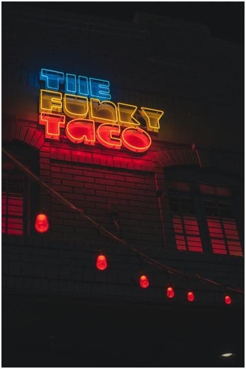 Eye-catching neon sign reading The Funky Taco agai