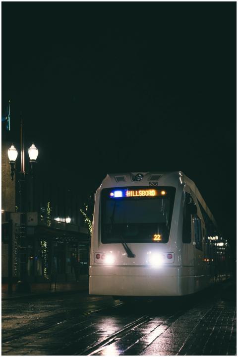 A tram travels through an illuminated city street