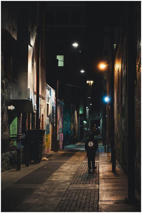 Mysterious urban alley at night with a lone figure