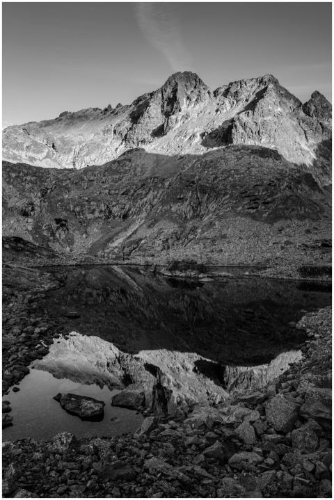 Black and white photo of a mountain reflected in a
