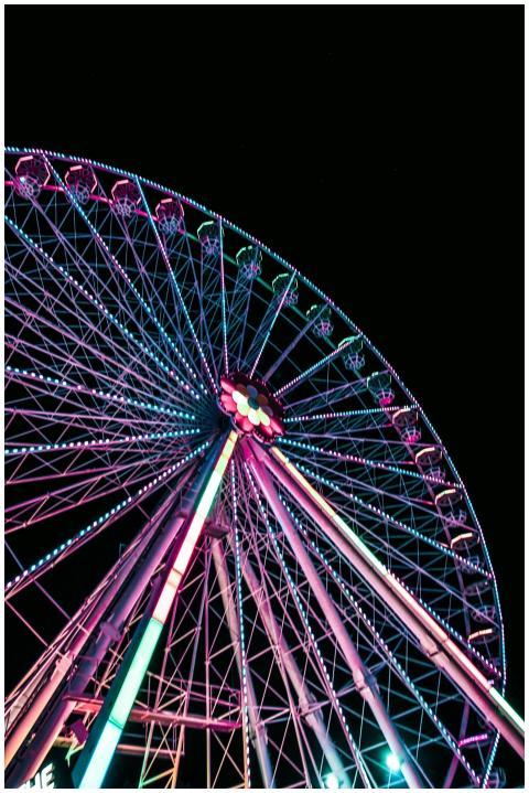 A brightly illuminated Ferris wheel with vibrant l