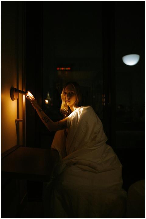Moody portrait of a woman by a lamp in a New York