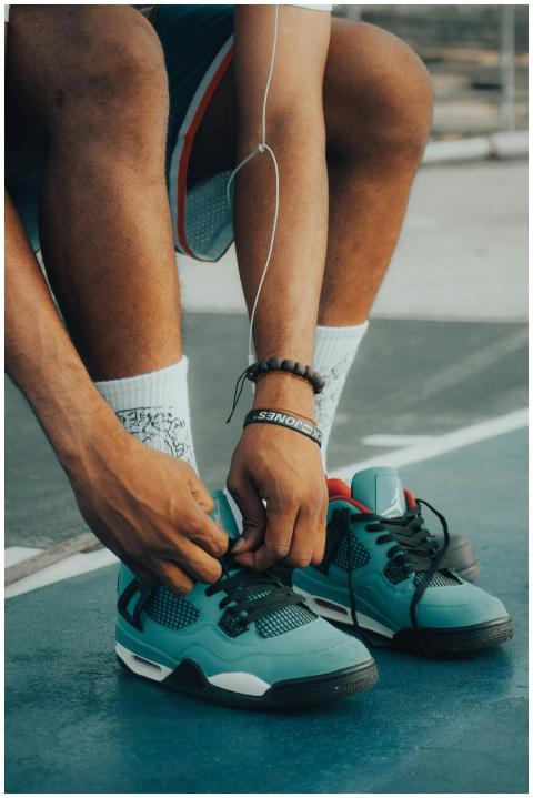 Close-up of a man tying his running shoes on an ou