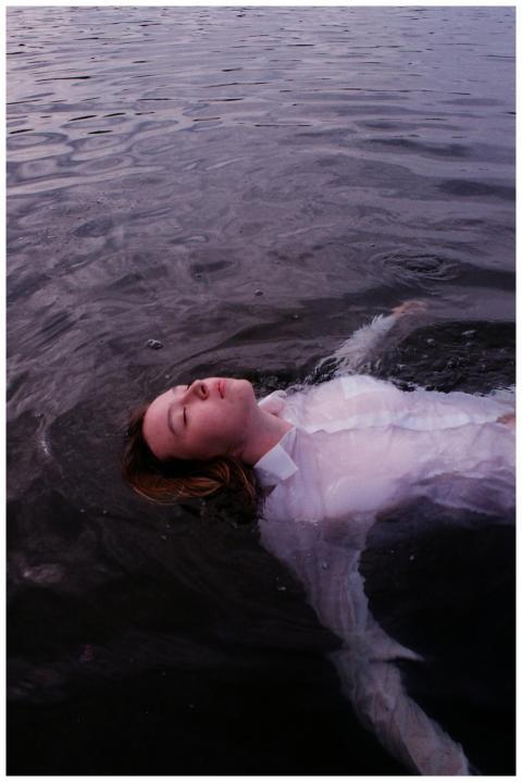 Woman peacefully floating in calm waters, creating