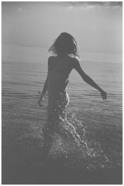 Black and white photo of a woman splashing in the