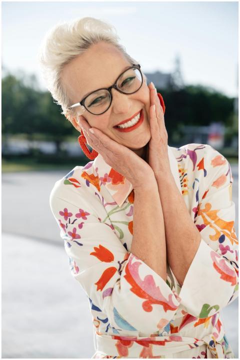 Elderly woman with eyeglasses smiling and posing o