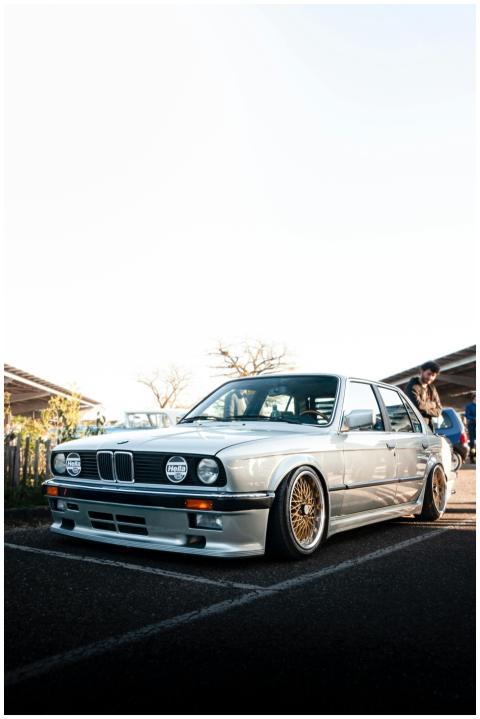 Vintage silver BMW sedan showcased at an outdoor c
