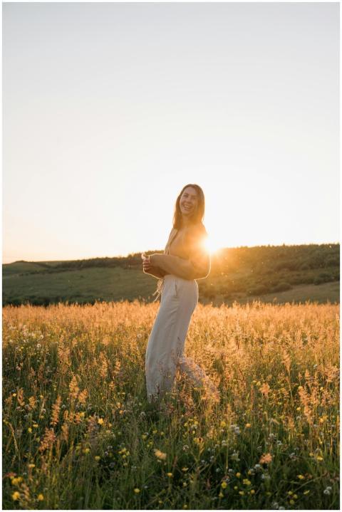 A woman in a field, embracing summer's golden hour