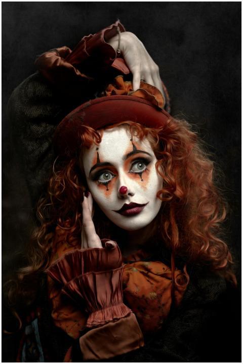 A striking portrait of a redhead woman in clown ma