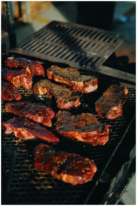 Sizzling steaks on a charcoal grill, perfect for a