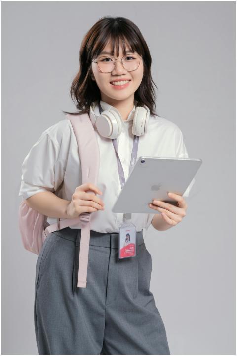 Smiling young woman holding a tablet with headphon
