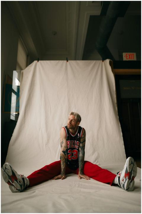 Athletic man in a basketball jersey poses indoors,