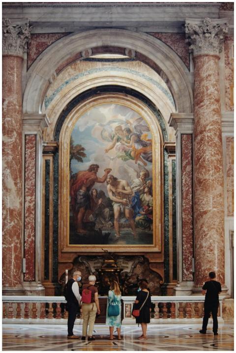A group of tourists observes a historic painting i