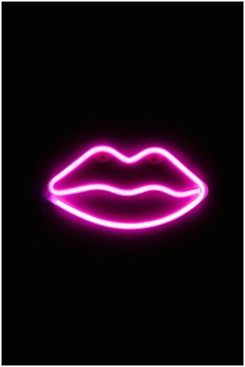 Vibrant neon pink lips decoration against a dark b