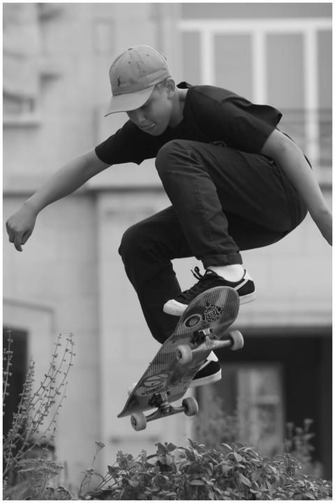 A young male skater in mid-air performing a jump w