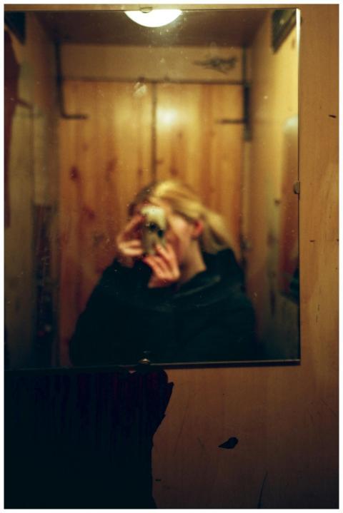 Artistic self-portrait in a dimly lit room using a