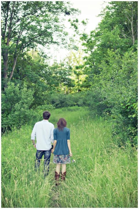 A couple holding hands as they walk through a lush
