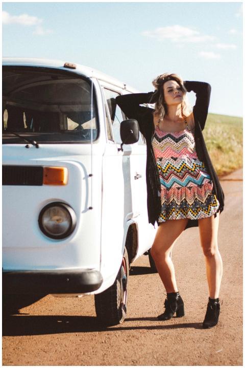 Stylish woman in sundress strikes a pose by a clas