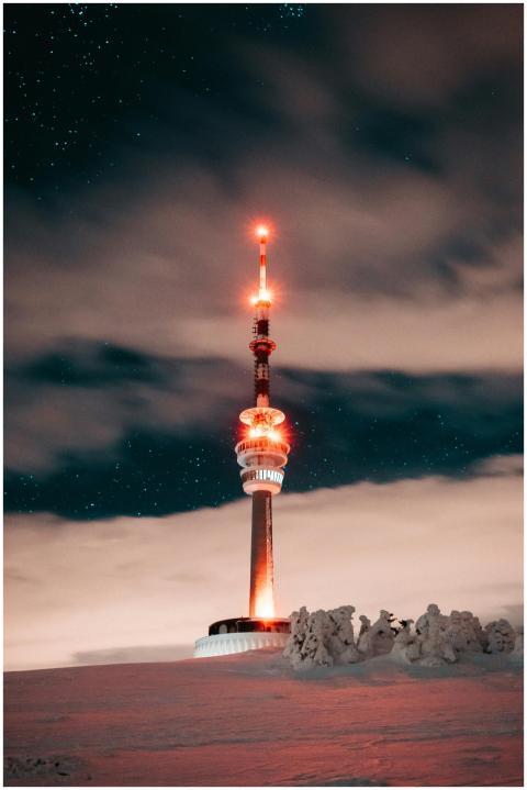 Illuminated Ještěd Tower under a starry sky in win