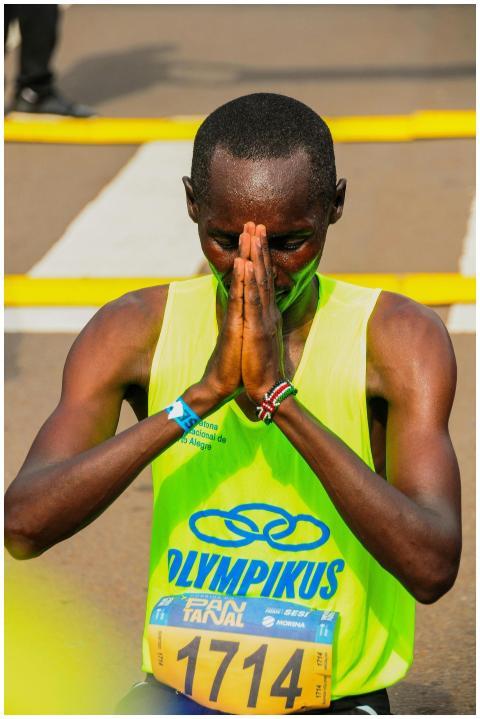 An athlete expressing gratitude at the finish line