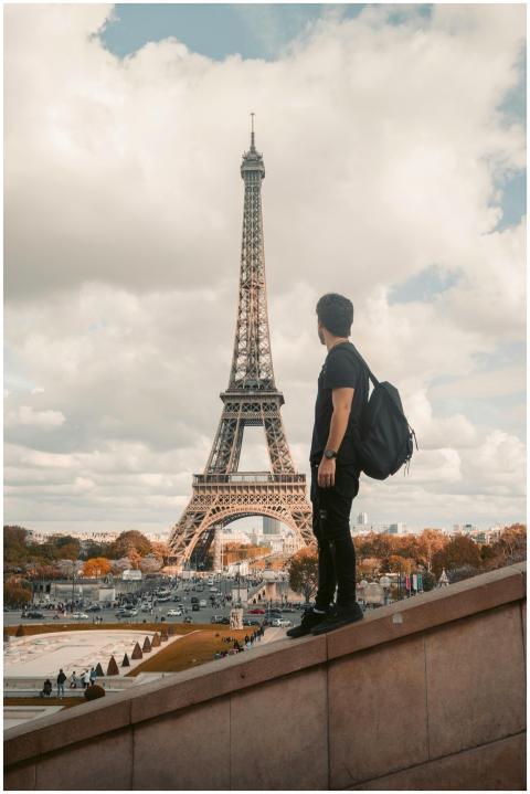 A tourist stands with a backpack admiring the Eiff