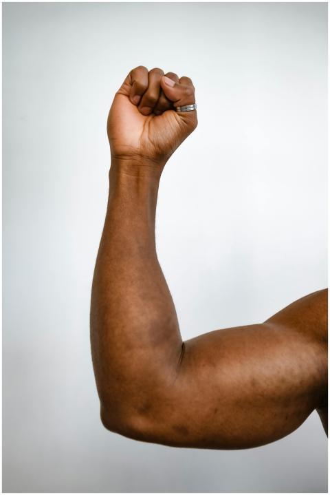 Vertical shot of a muscular arm showing strength w