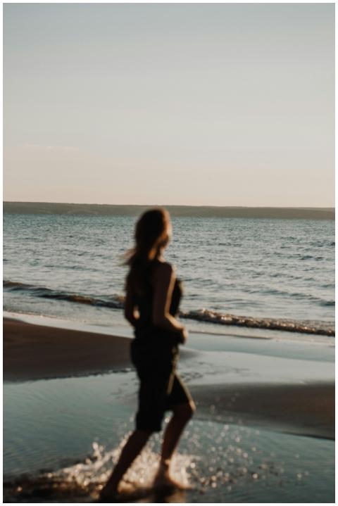 A woman enjoying a tranquil run along the beach at
