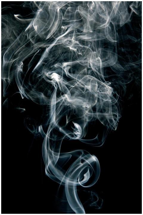 Intricate patterns of swirling smoke on a black ba