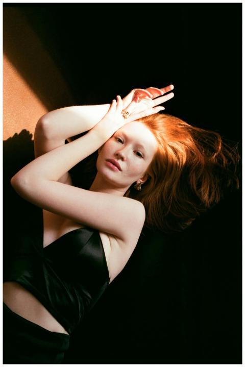 Striking portrait of a red-haired woman posing gra