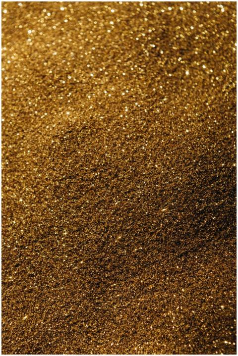 Close-up of sparkling golden sand, perfect for bac