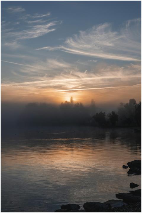 Enchanting sunrise over a misty lake with serene r