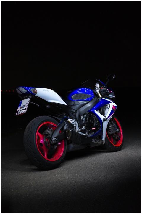 A sleek white and blue Suzuki sport bike parked on